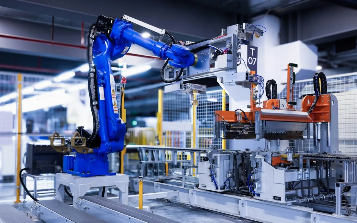 A blue industrial robot arm on a factory automation line