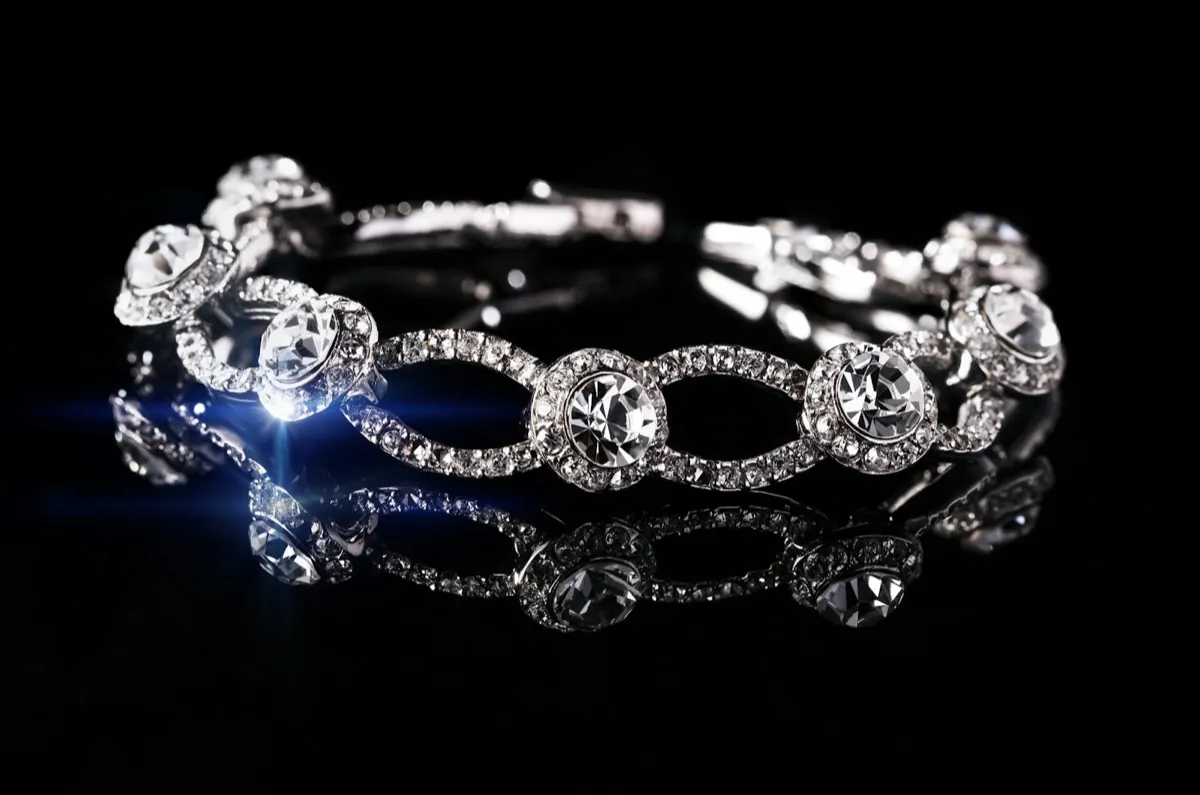 A diamond-set fine jewelry bracelet on a dark reflective surface